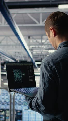 vertical video software developer in data center checks ai dashboard using laptop
