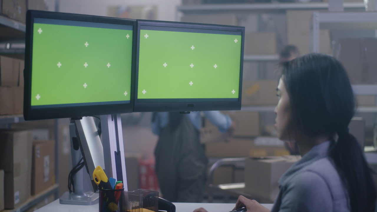 Warehouse worker looking at computer screens