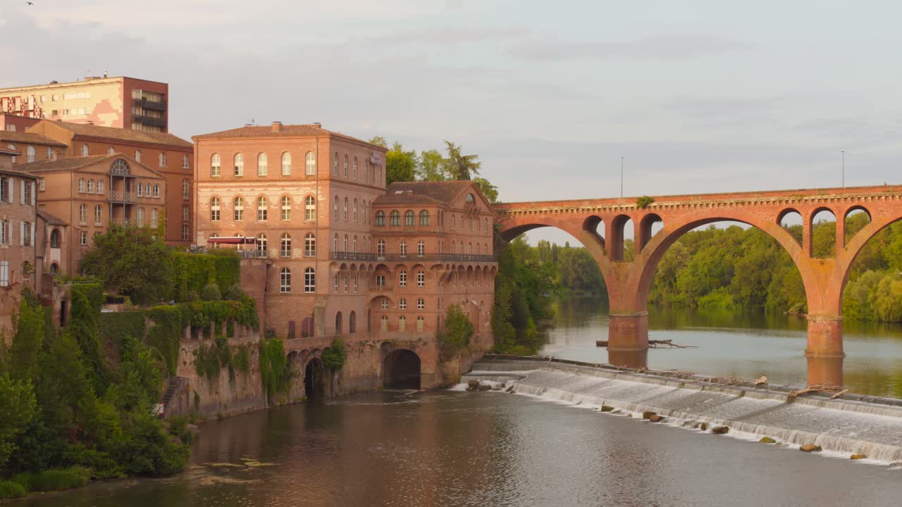 Explore picturesque Albi, France, showcasing the iconic bridge linking the city's two sides. The serene Tarn River reflects the stunning architecture, evoking a tranquil atmosphere at sunset