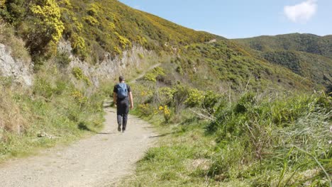 a day hiker walking up a steep gravel trail