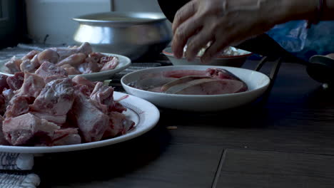 Close-Up-View-Of-Raw-Meat-On-Plate-On-Floor-With-Hands-Of-Women-Slicing-The-Raw-Fish-Small-Pieces-on-Eid-al-Adha