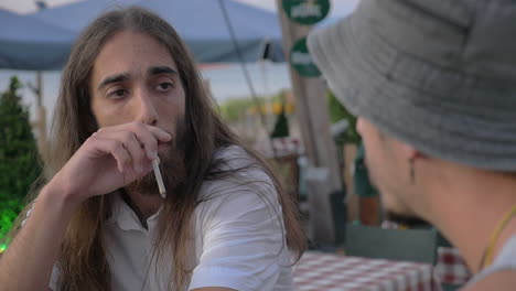 dos amigos hablando en un café al aire libre