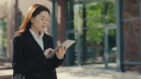 mujer de negocios usando tableta al aire libre