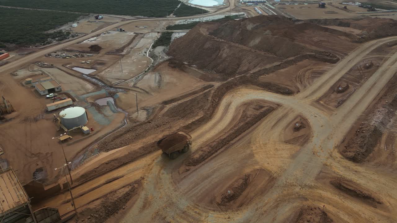 Truck carrying nickel to unload in mine site. Aerial top-down orbiting