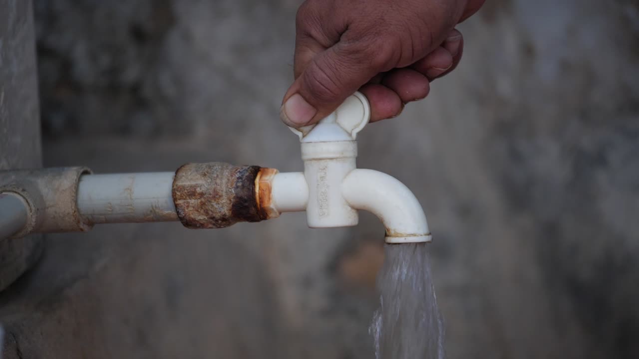 abrir el grifo de agua del pueblo indio con la mano de un hombre