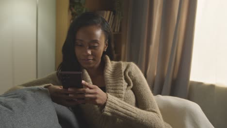 man sitting next to woman on sofa at home using mobile phone and talking 1