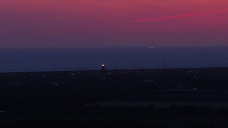 bright light of a nautical lighthouse in zeeland after a colorful sunset