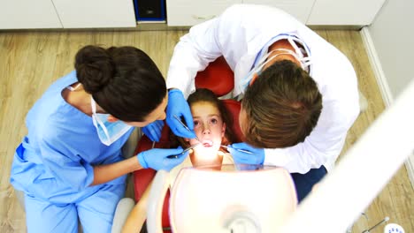 Dentists-examining-a-young-patient-with-tools