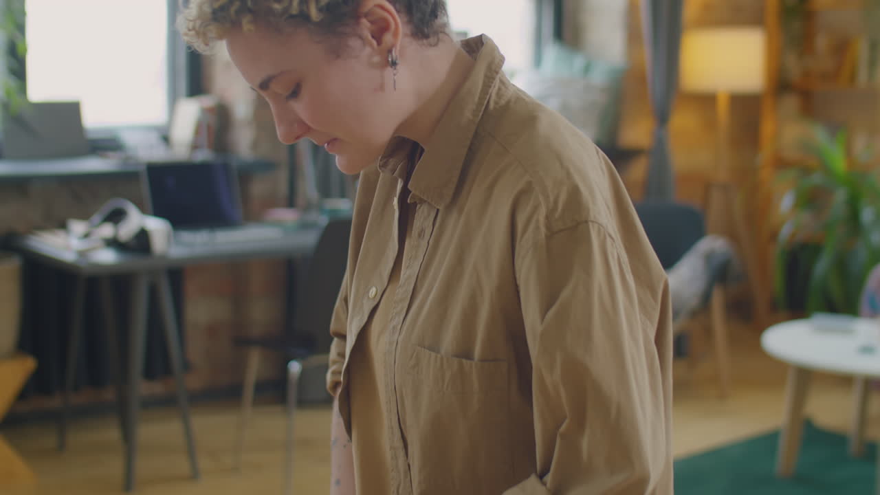 Girl with Prosthetic Arm Cutting Cucumber at Kitchen Table