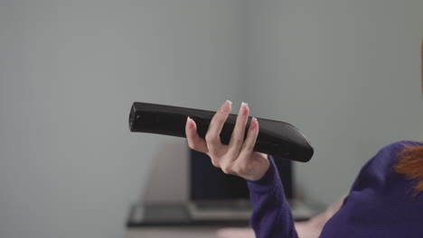 hand of woman holding remote control on blurred background