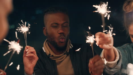 happy-friends-holding-sparklers-celebrating-new-years-eve-birthday-party-at-night-having-fun-holiday-celebration-gathering-on-rooftop