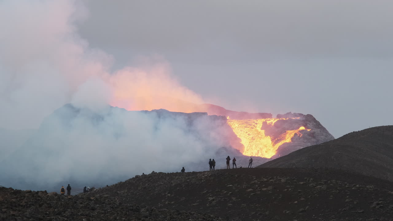 Tourists watching Iceland's newest active volcano Geldingadalur erupt