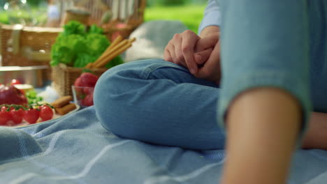 피크닉 담요 클로즈업에 알려지지 않은 인간의 다리.  ⁇ 은 야외에 앉아있는 여자.