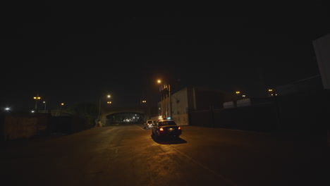 tiro de seguimiento fpv lento de coches de policía con luces intermitentes que responden a una emergencia
