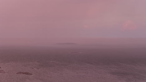 telephoto aerial of a rain pouring over an island on the gulf of finland, dusk