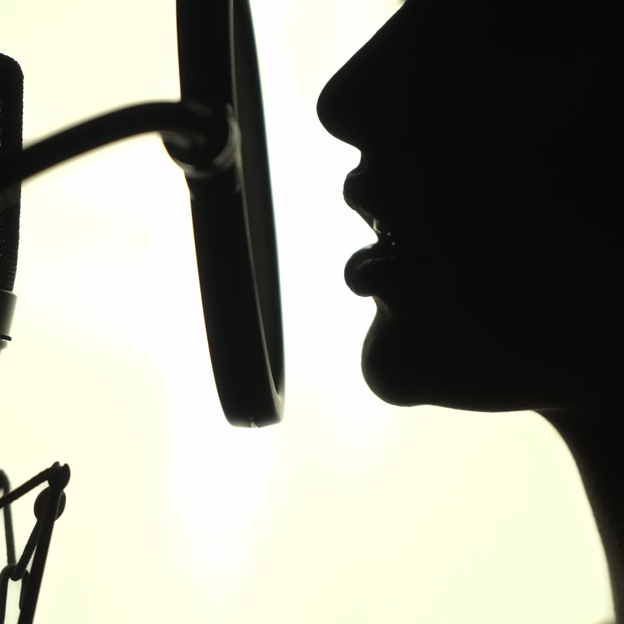 Silhouette of a woman singing a song in a recording studio. Black and White.