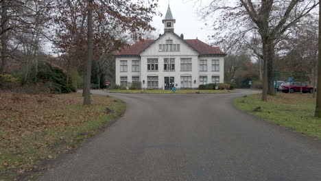 Moving-over-small-road-towards-old-manor-with-clocktower