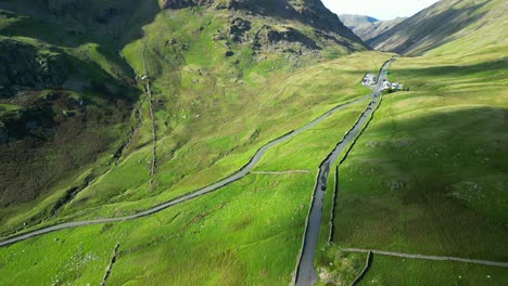 Reveal-of-top-of-mountain-pass-with-cars-and-tourists-gathering-as-cloud-shadows-move-across-landscape-on-summer-day