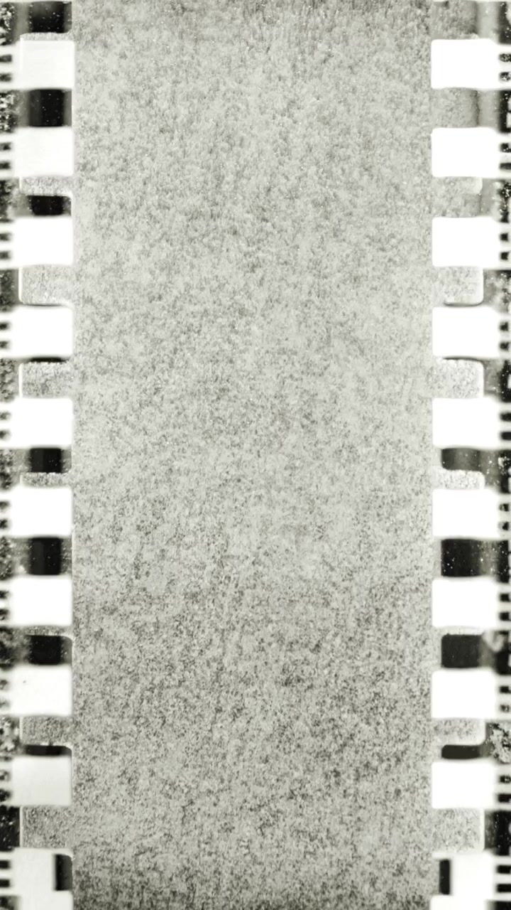 Striscia di pellicola vintage in movimento con grana e perforazioni