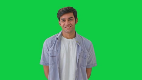 happy young indian boy listening to someone green screen