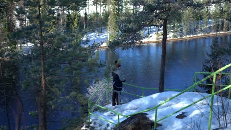 women standing next to river, putting on gloves, cold winter day in boreal nordic landscape, static