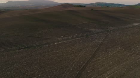 Low-aerial-over-a-ploughed-field-in-Tuscany,-Province-of-Siena,-Italy