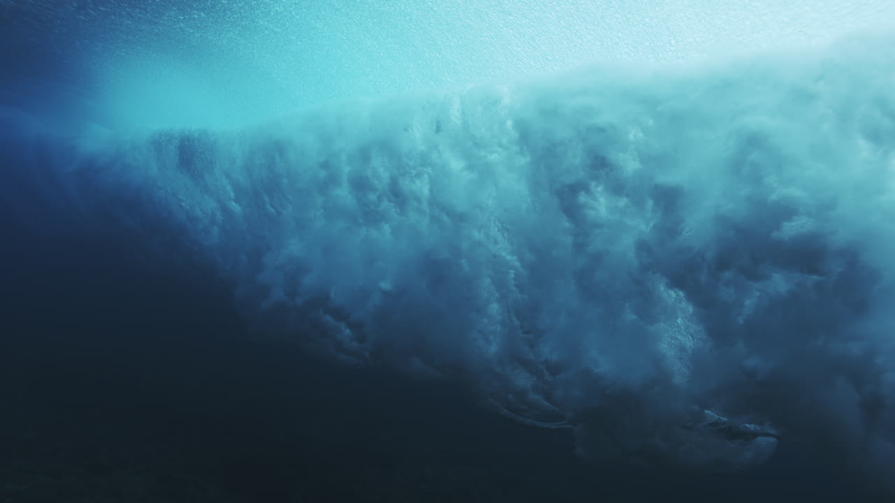Curving underwater wave wall glowing turquoise with smooth flowing ocean texture