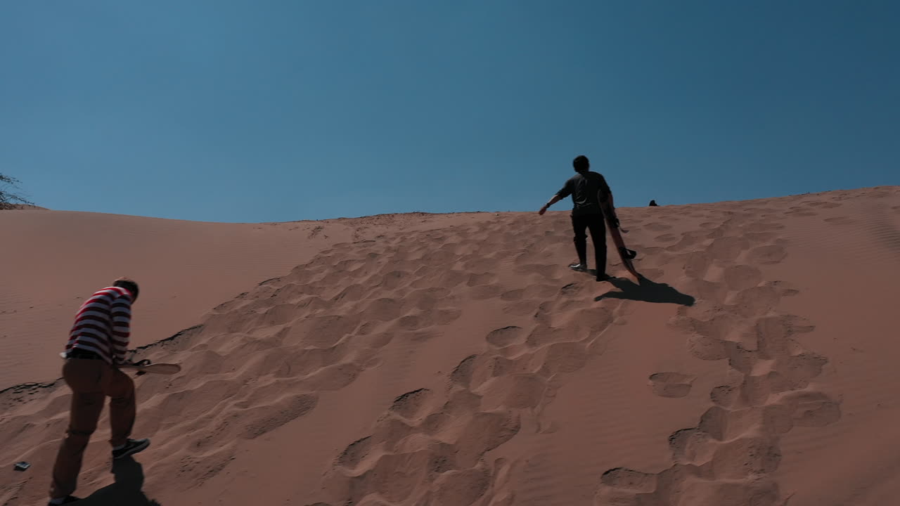 a man with sandboard. Huacachina, Peru, desert, drone aerial