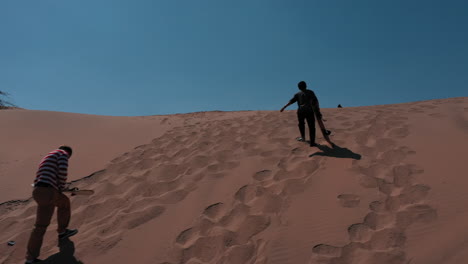 a man with sandboard. huacachina, peru, desert, drone aerial