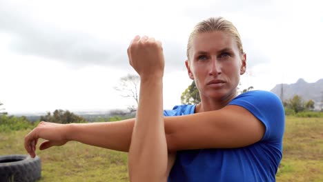 Fit-woman-performing-stretching-exercising-during-obstacle-course