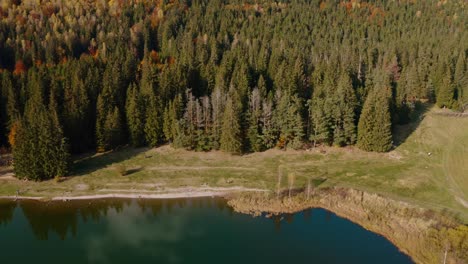 Lago-Sfanta-Ana-En-Otoño-Con-Coloridos-Reflejos-Forestales,-Vista-Aérea