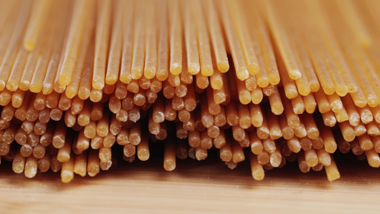 Primo piano di spaghetti crudi su una superficie di legno