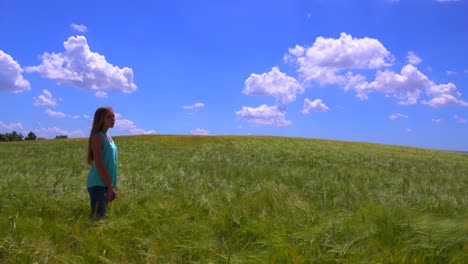 A-young-girl-walks-along-a-dirt-road-near-a-field-of-wildflowers-1