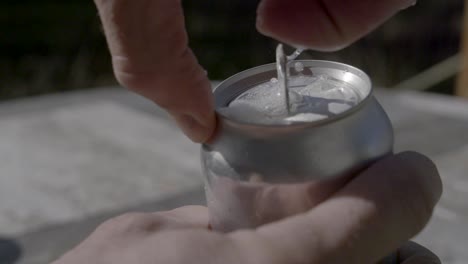 apertura lenta de una lata de cerveza o refresco con salpicaduras