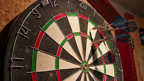 darts hitting 38 points on an old rubber board hanging on a basement wall