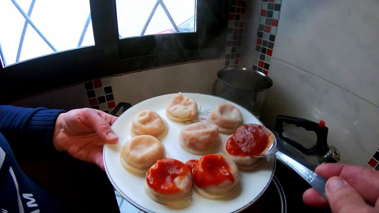 Woman putting tomato sauce with a spoon, Italian pasta in the kitchen