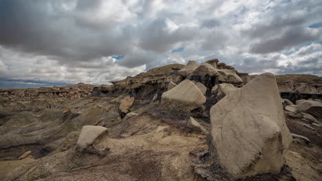 laps de temps sauvage des badlands bisti, formant des formes de nuages au-dessus du paysage désertique sec et des formations rocheuses, plein cadre