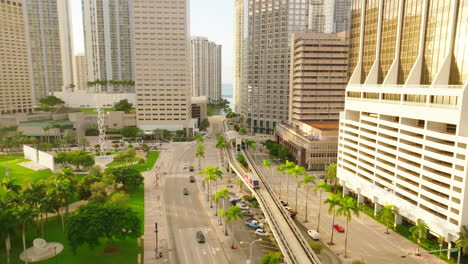 Small-subway-train-moving-in-the-middle-of-the-sunny-city-downtown-lit-with-warm-sun-rays