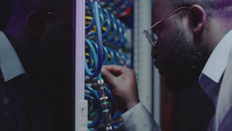 african american technician checking server cables