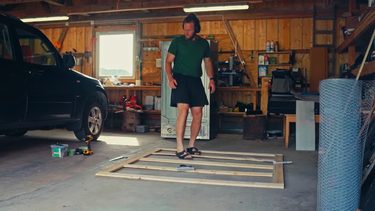 Timelapse di un uomo che realizza una finestra a rete metallica all'interno del garage.