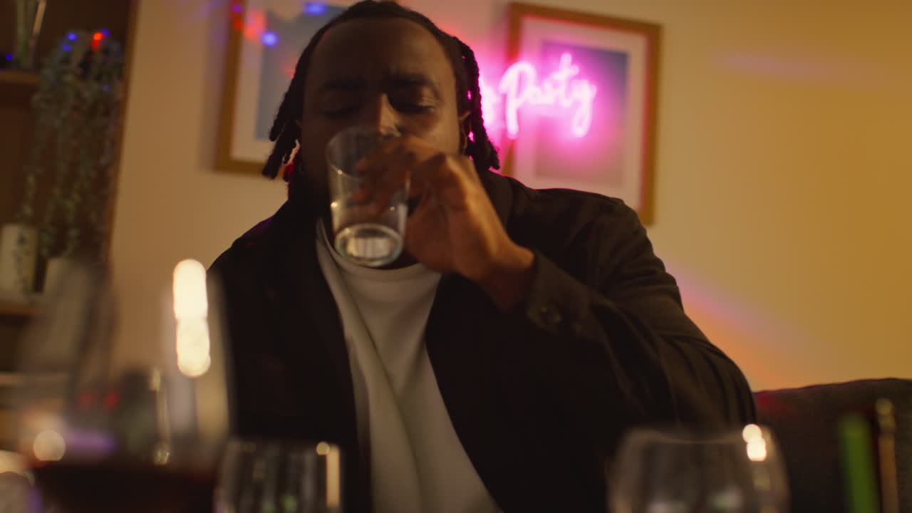 Man Sitting On Sofa After Drinking Alcohol At House Party Taking Medication For Hangover 1