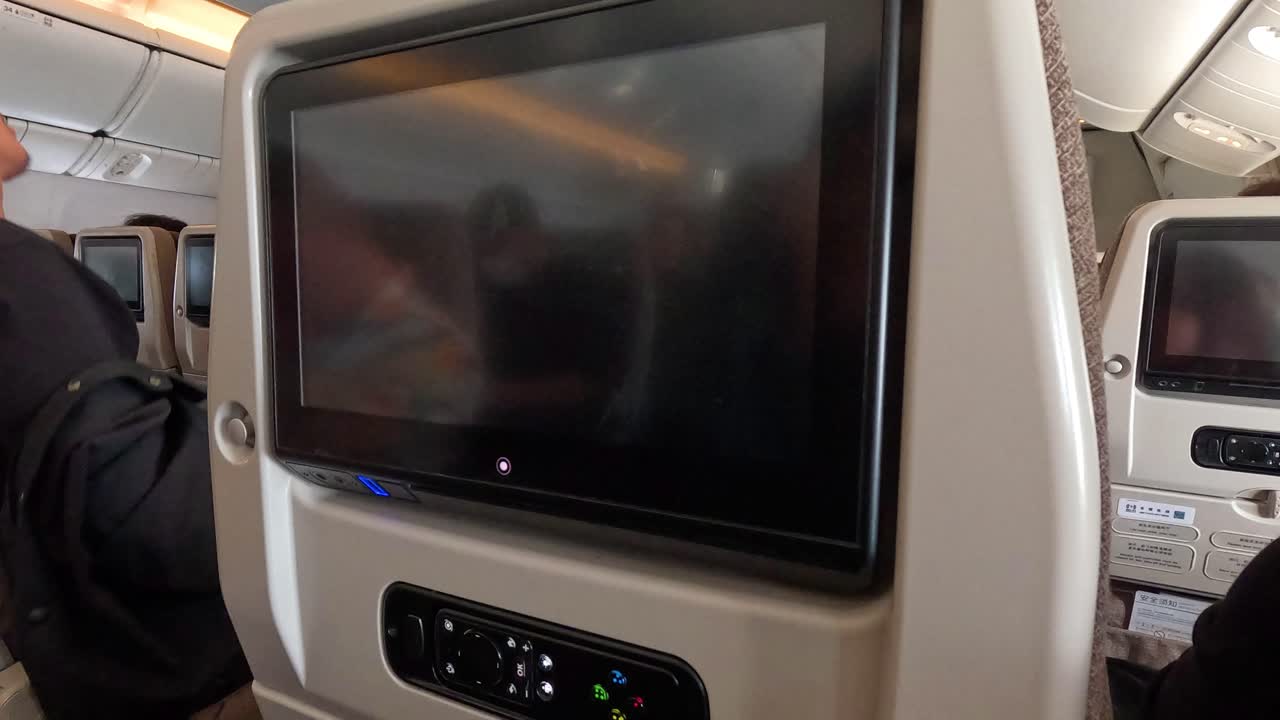 승객들이 기내 엔터테인먼트 스크린 근처에서 상호 작용합니다.