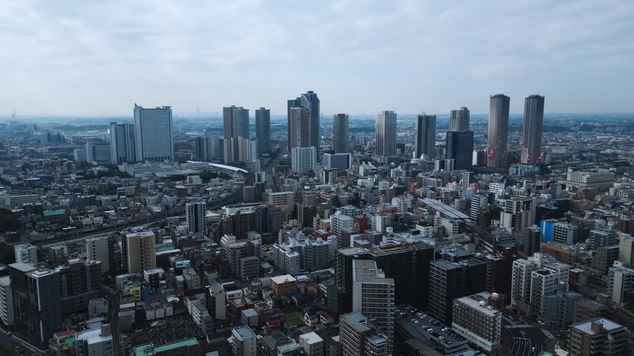 Drone moves sideways over Musashi Kosugi Tokyo area under cloudy hazy daylight