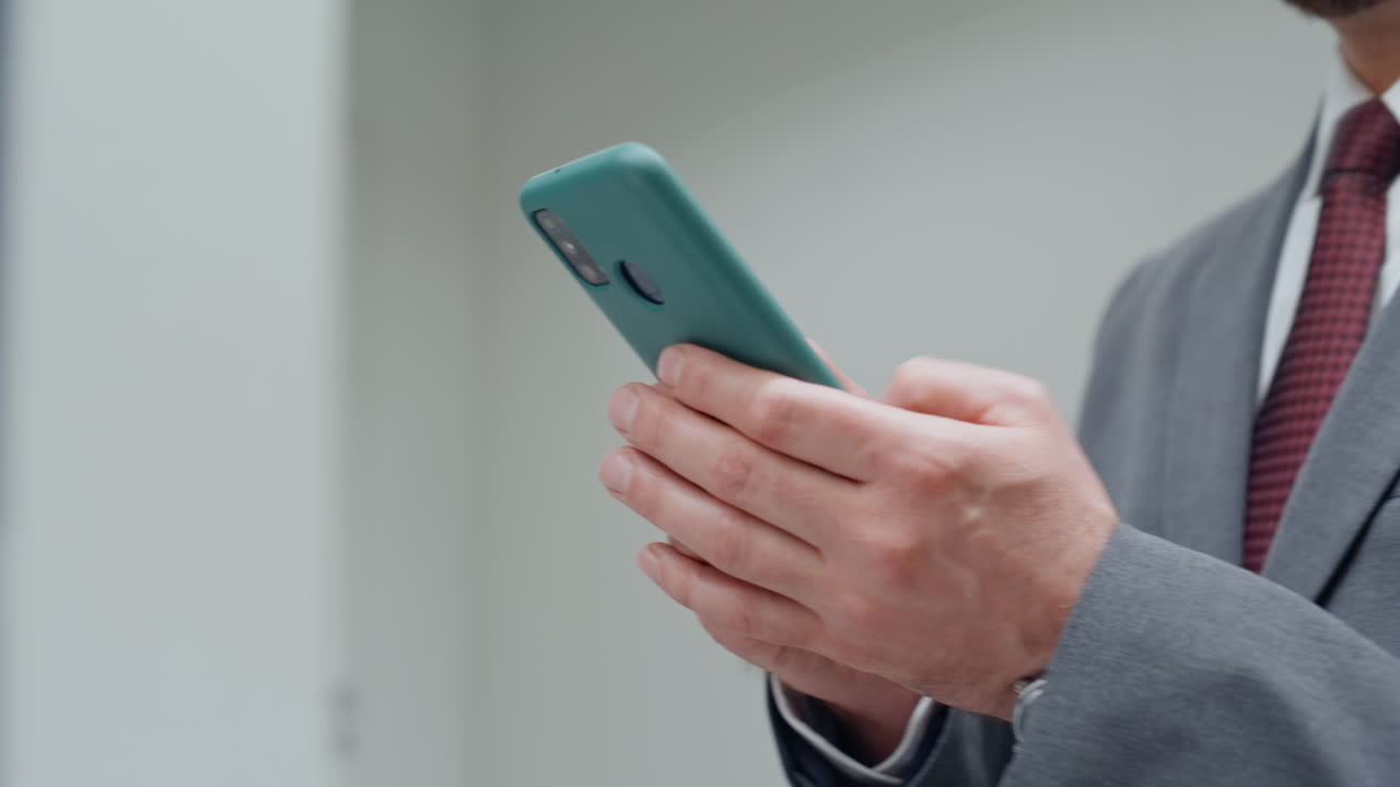 Manager hands texting smartphone strolling office corridor closeup. Man typing