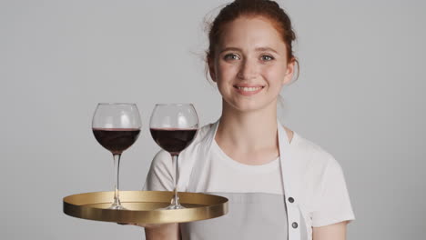 Redheaded-waitress-in-front-of-camera-on-gray-background.