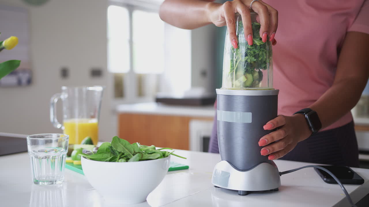 Woman Blending Healthy Juice Drink With Fresh Ingredients In Electric Juicer After Exercise