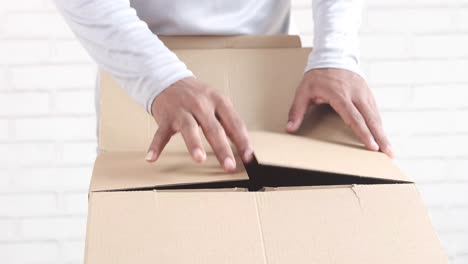 person opening a cardboard box