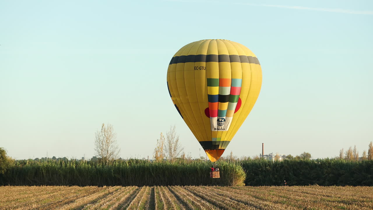 Mongolfiera gialla che vola sopra campi rurali a Coruche, Ribatejo, Portogallo