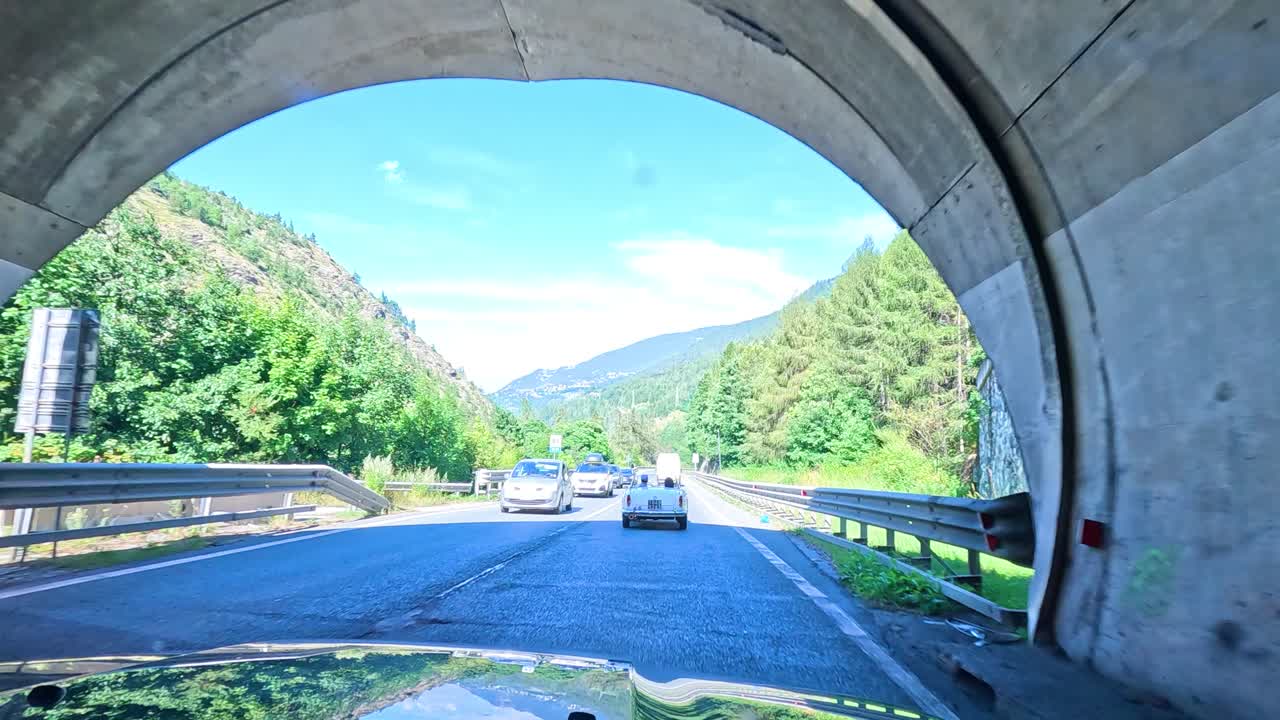 차가 터널에서 나와 경치 좋은 산길로 들어갑니다.
