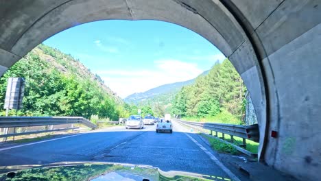 car exits tunnel into scenic mountain road